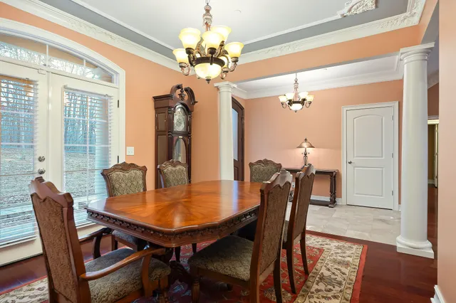 a dining room with furniture a chandelier and wooden floor
