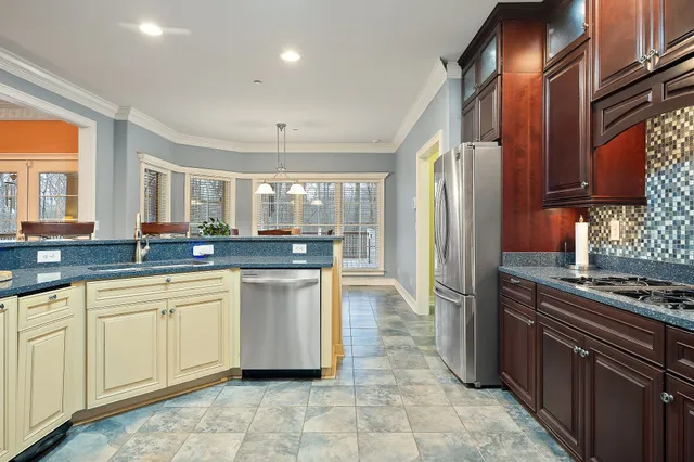 a kitchen with stainless steel appliances granite countertop a refrigerator and a stove