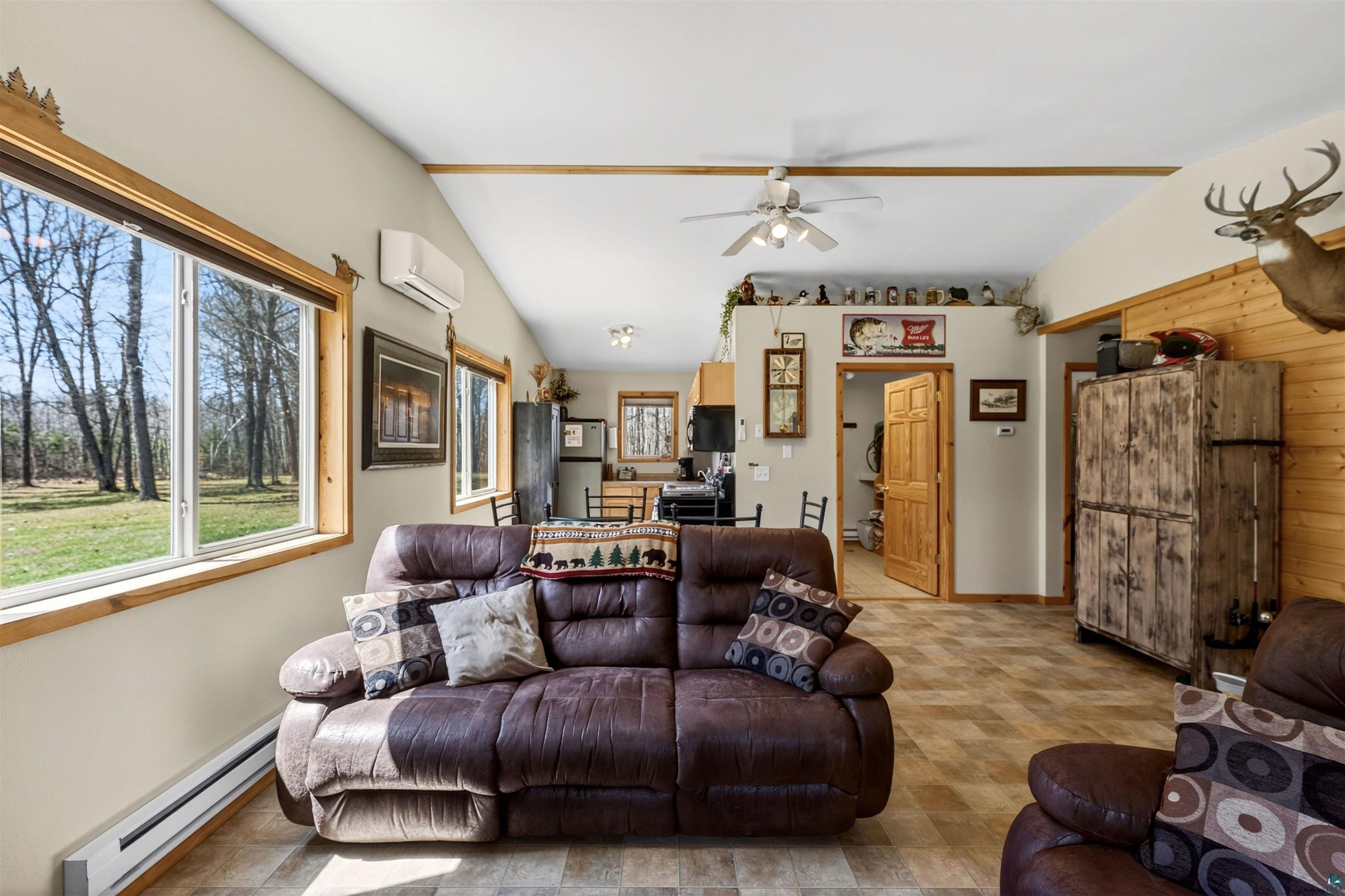 12235 East Crooked Lake Road Gordon, WI 54838 - Photo 11 of 48 Spacious living area featuring vaulted ceilings, wood-finish flooring, and natural wood trim accents