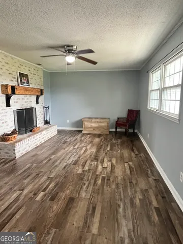 a view of a hallway view with wooden floor and a bathroom