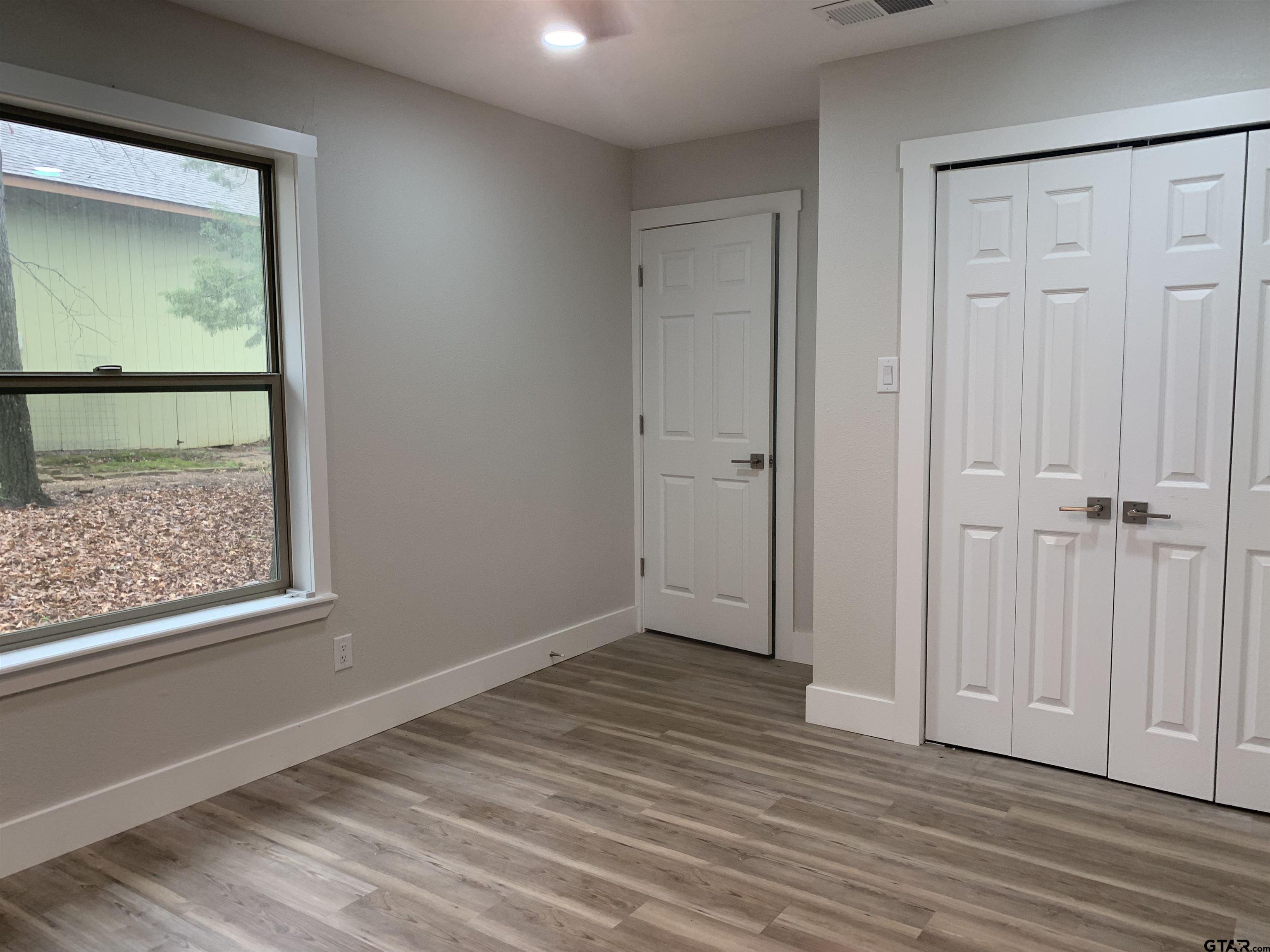 224 Miller Road Scroggins, TX 75480 - Photo 14 of 24 a view of an empty room with wooden floor and a window