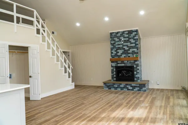 a view of a livingroom with wooden floor and a fireplace
