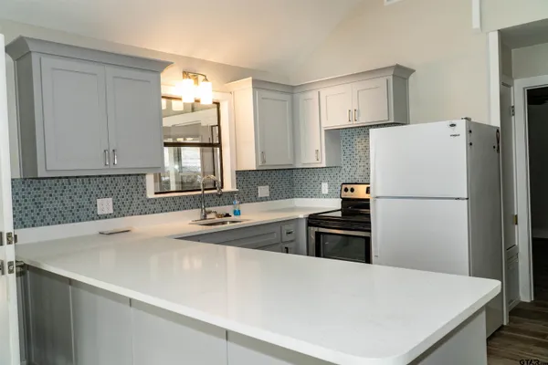 a kitchen with a refrigerator a sink and a stove
