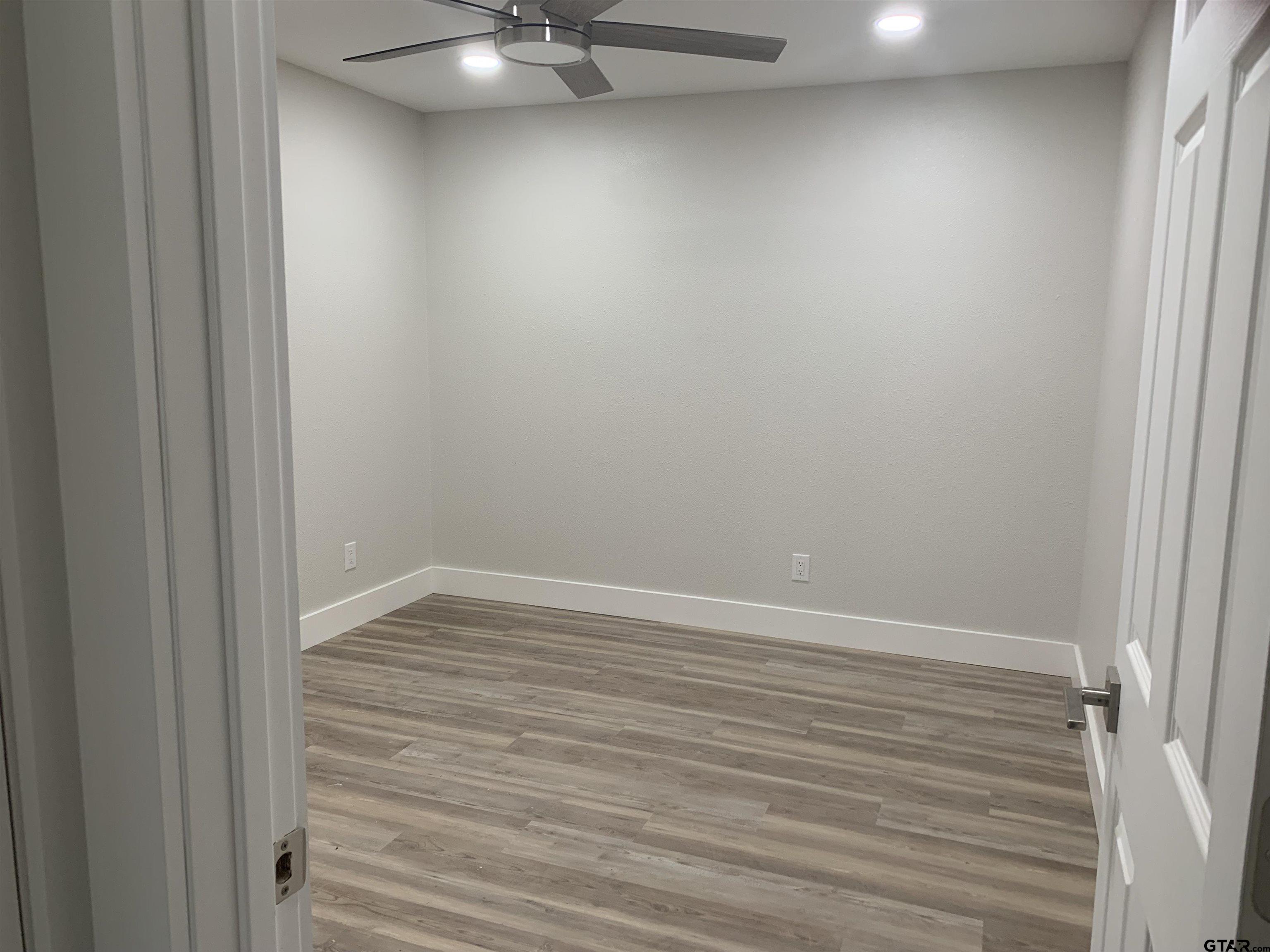 224 Miller Road Scroggins, TX 75480 - Photo 10 of 24 en empty room with wooden floor and fan