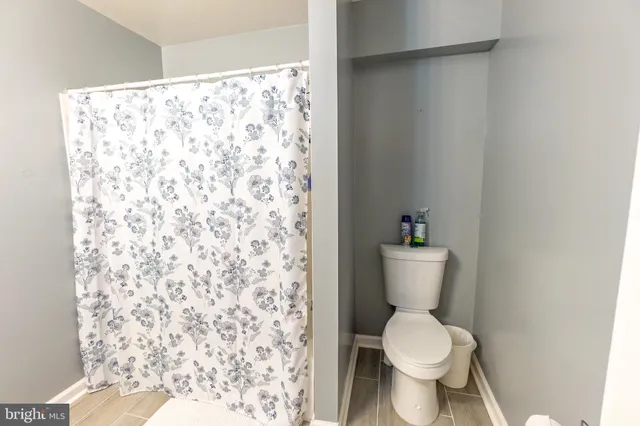 a white toilet sitting next to a shower curtain