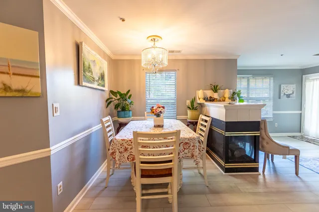 a living room with furniture a dining table wooden floor and a chandelier