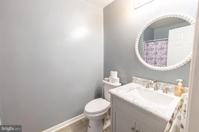 a bathroom with a granite countertop toilet and a sink