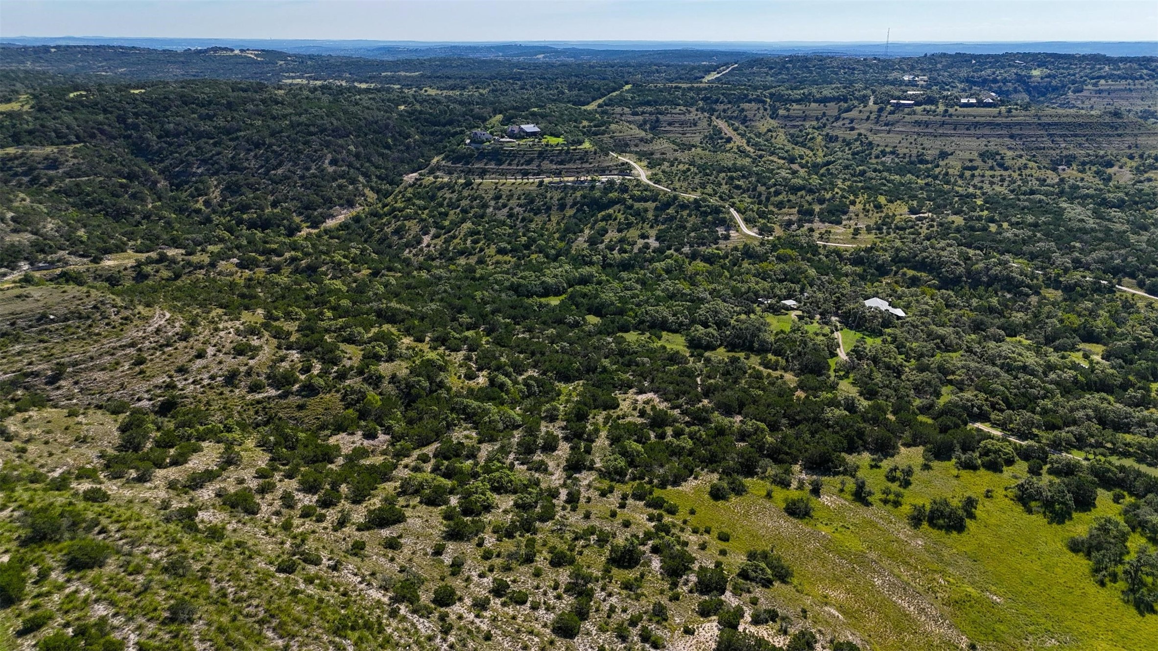 1215 Montell Road Wimberley, TX 78676 - Photo 27 of 38 an aerial view of a houses with a green hillside