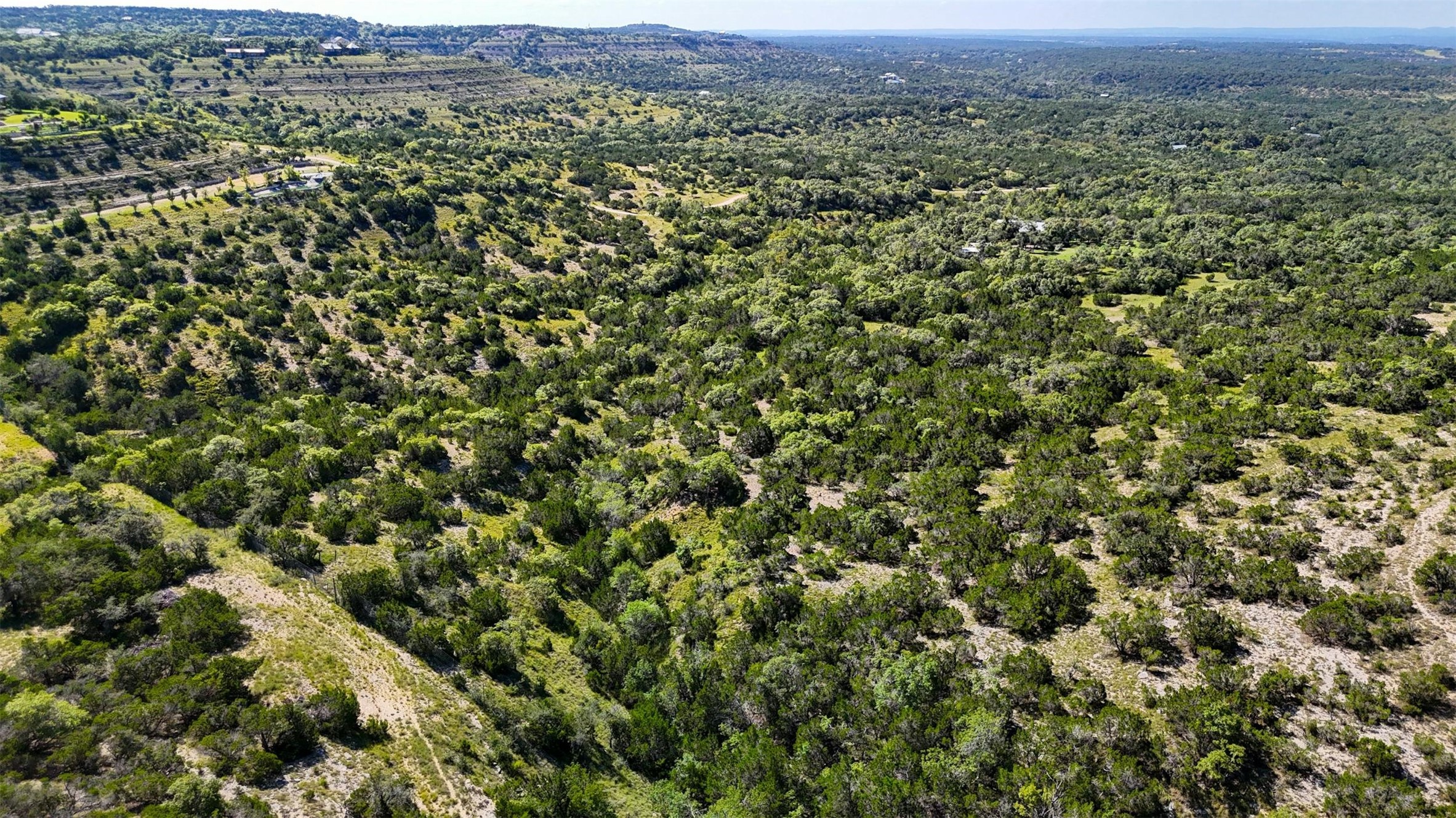 1215 Montell Road Wimberley, TX 78676 - Photo 8 of 38 a view of a green field with lots of bushes