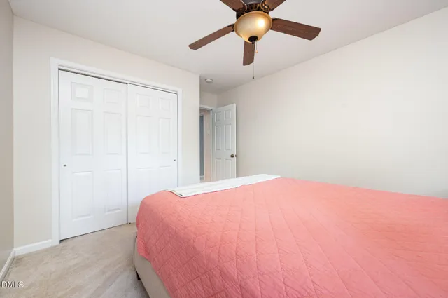 a bedroom with a bed and a ceiling fan