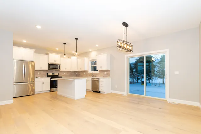 a kitchen with a refrigerator and countertop sink