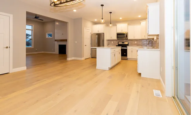 a view of kitchen and kitchen with granite countertop a refrigerator a sink
