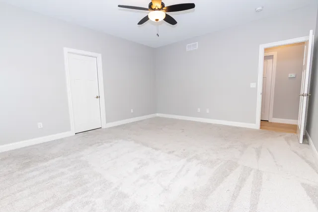wooden floor in an empty room with a ceiling fan