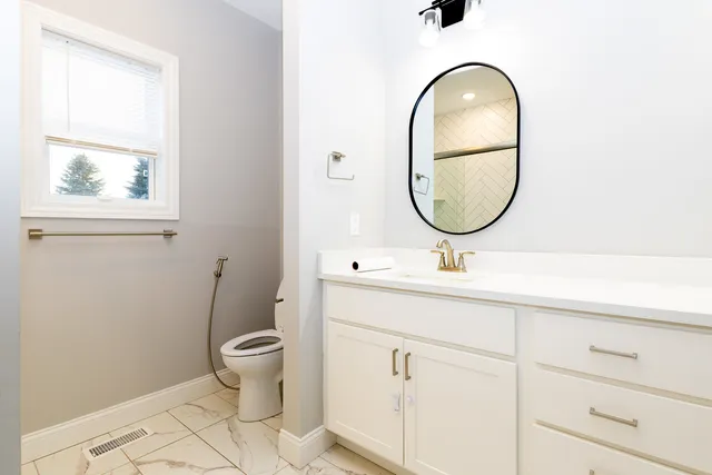 a bathroom with a toilet a sink and a mirror