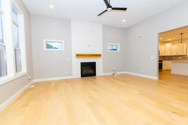 a view of empty room with a fireplace and wooden floor