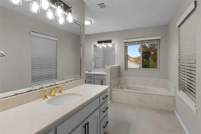 a bathroom with a tub a sink and a window