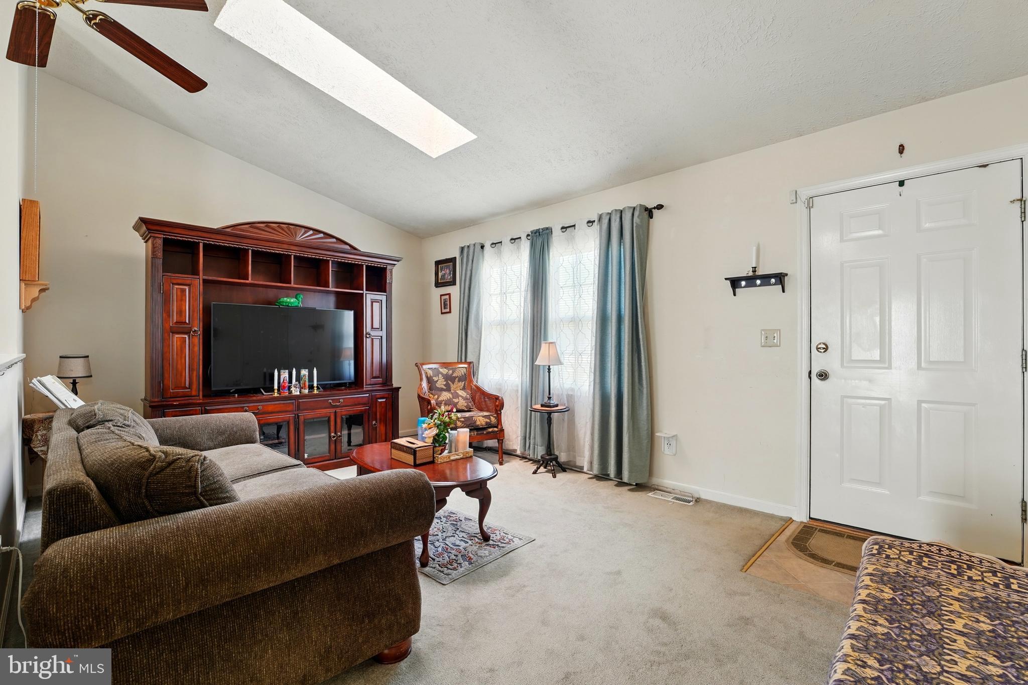 6775 Rugby Place Bealeton, VA 22712 - Photo 11 of 43 a living room with furniture a flat screen tv and a floor to ceiling window