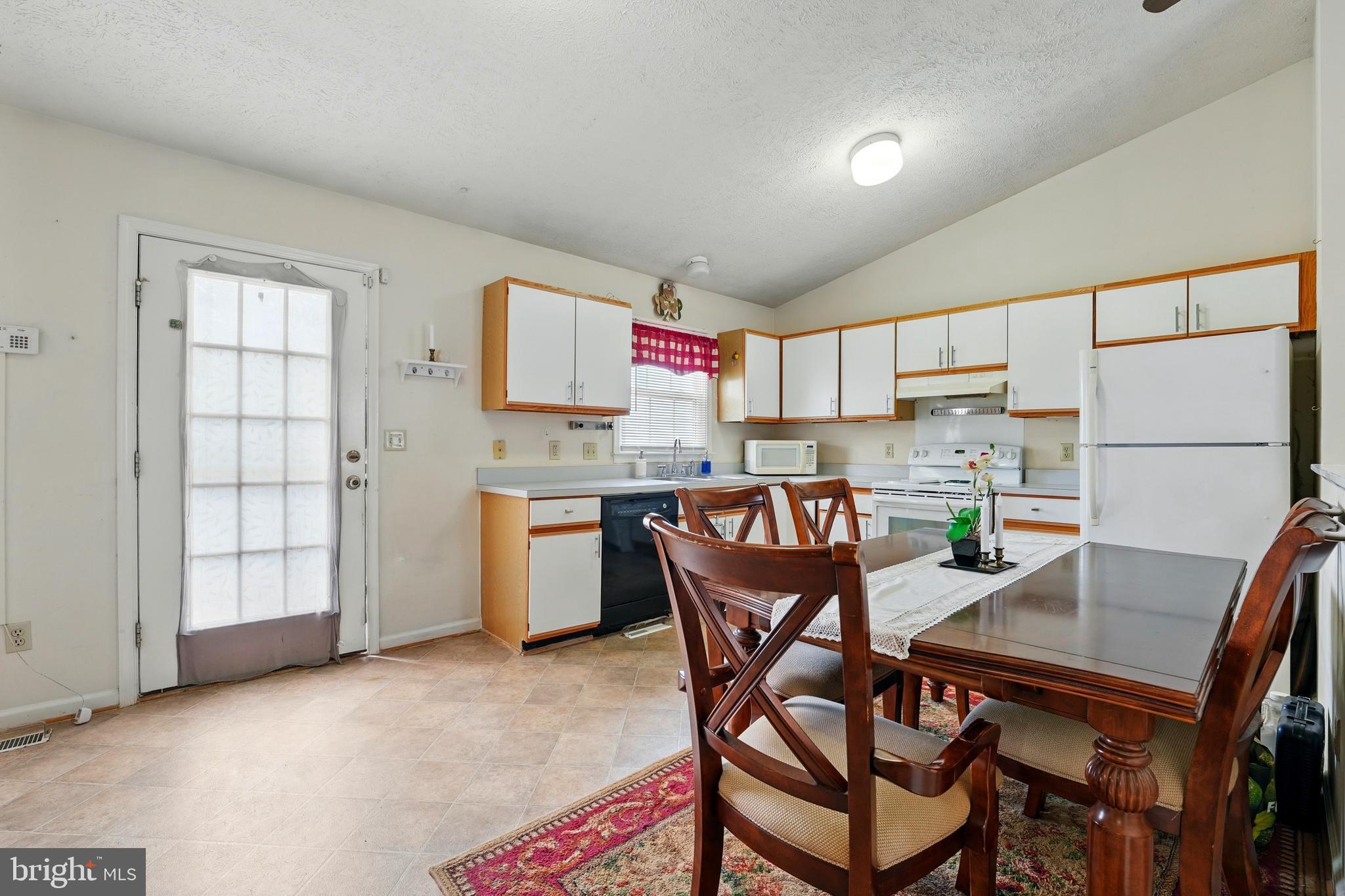 6775 Rugby Place Bealeton, VA 22712 - Photo 14 of 43 a kitchen with granite countertop a refrigerator a stove a sink dishwasher and white cabinets with wooden floor