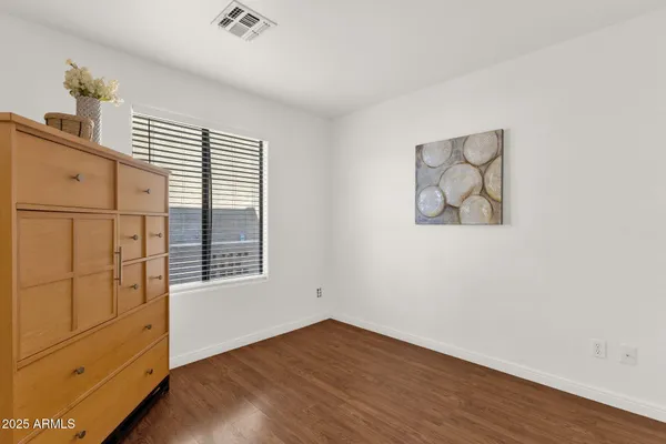 an empty room with wooden floor cabinet and window