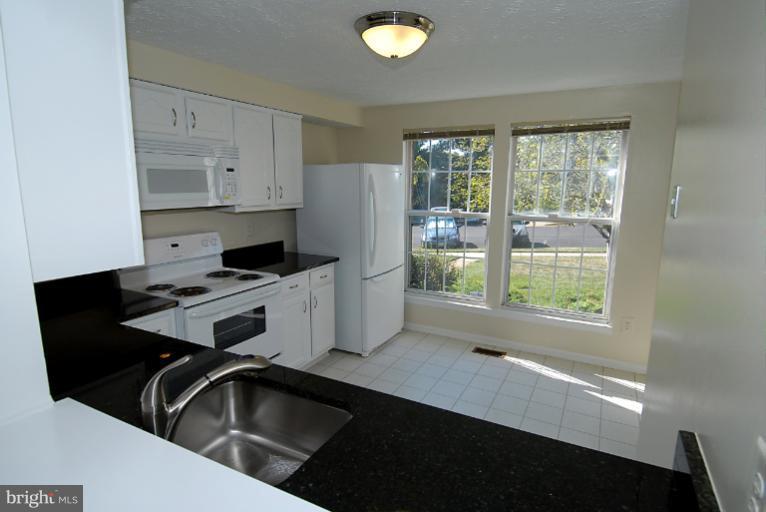 1489 Autumn Ridge Circle Reston, VA 20194 - Photo 12 of 23 a kitchen that has a sink a stove and a window