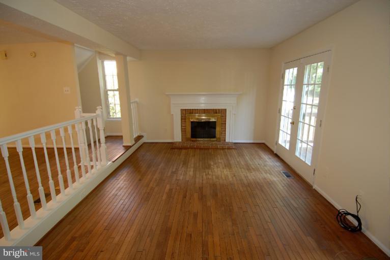 1489 Autumn Ridge Circle Reston, VA 20194 - Photo 8 of 23 a view of an empty room with wooden floor fireplace and a window