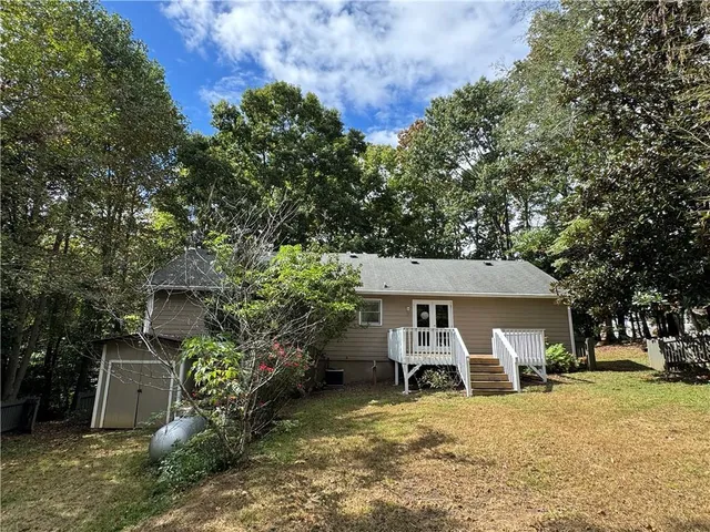 a view of a house with backyard and sitting area
