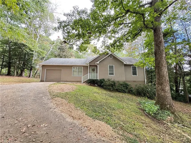 a view of a house with a yard and large tree