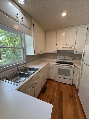 a kitchen that has a sink cabinets counter space appliances and a window