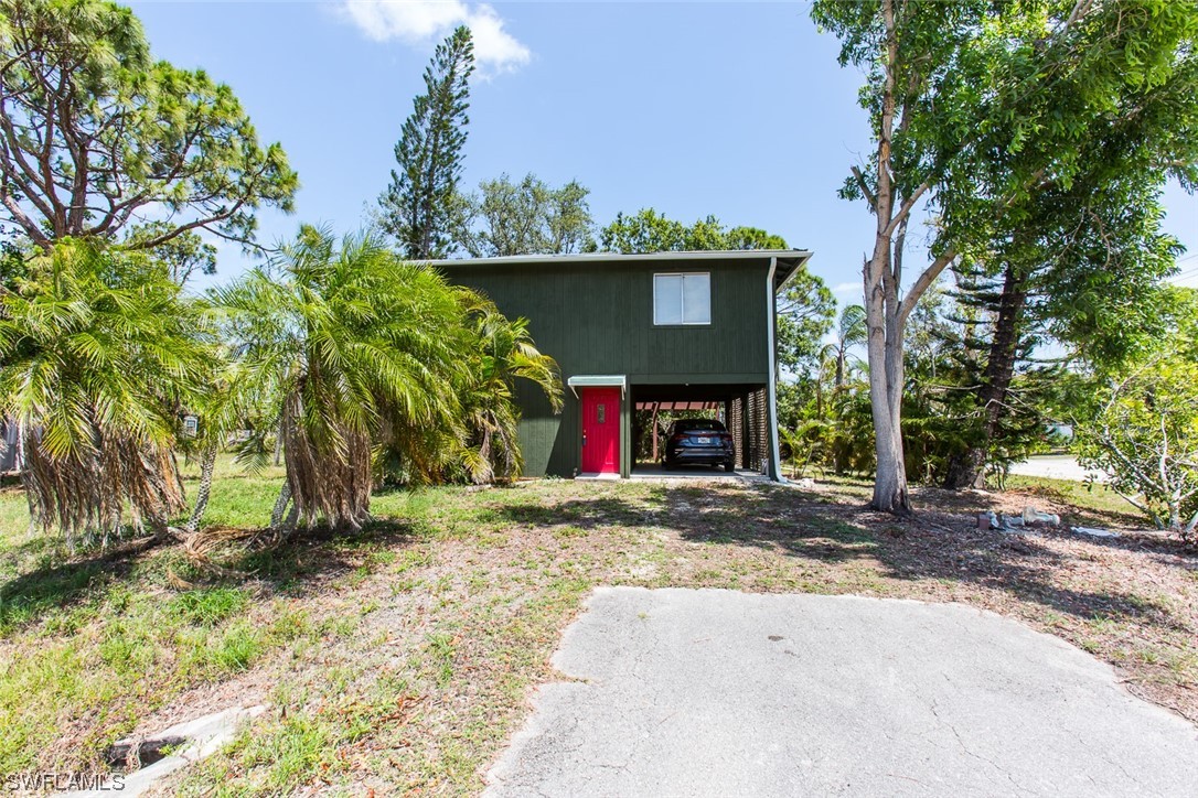 8469 Cardinal Road Fort Myers, FL 33967 - Photo 8 of 44 a view of a house with a tree and a yard