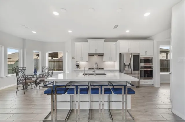 a large kitchen with a table and chairs