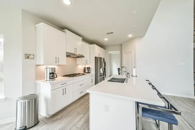 a kitchen with stainless steel appliances a sink stove and cabinets