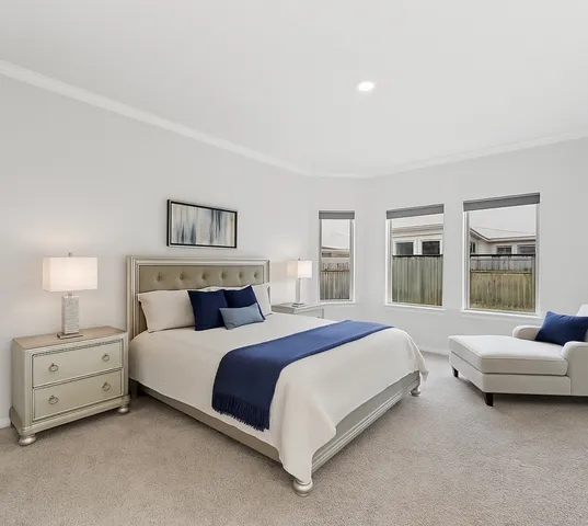 a spacious bedroom with a bed a couch and a window