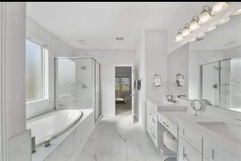 a spacious bathroom with a bathtub shower sink double and mirror