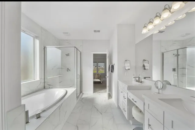 a spacious bathroom with a bathtub shower sink double and mirror