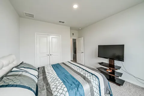 a bedroom with a bed and a flat screen tv