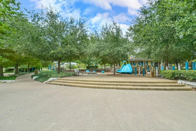 a view of a lake with a yard and large trees