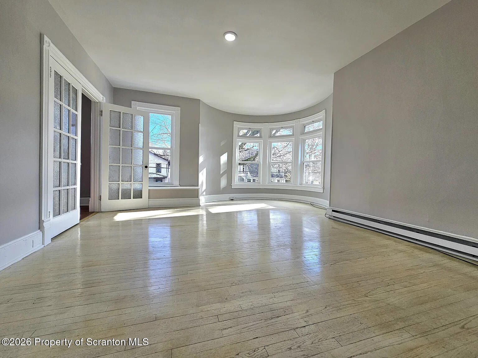 1615 Monsey Avenue Scranton, PA 18509 - Photo 4 of 10 a view of empty room with wooden floor and floor to ceiling window