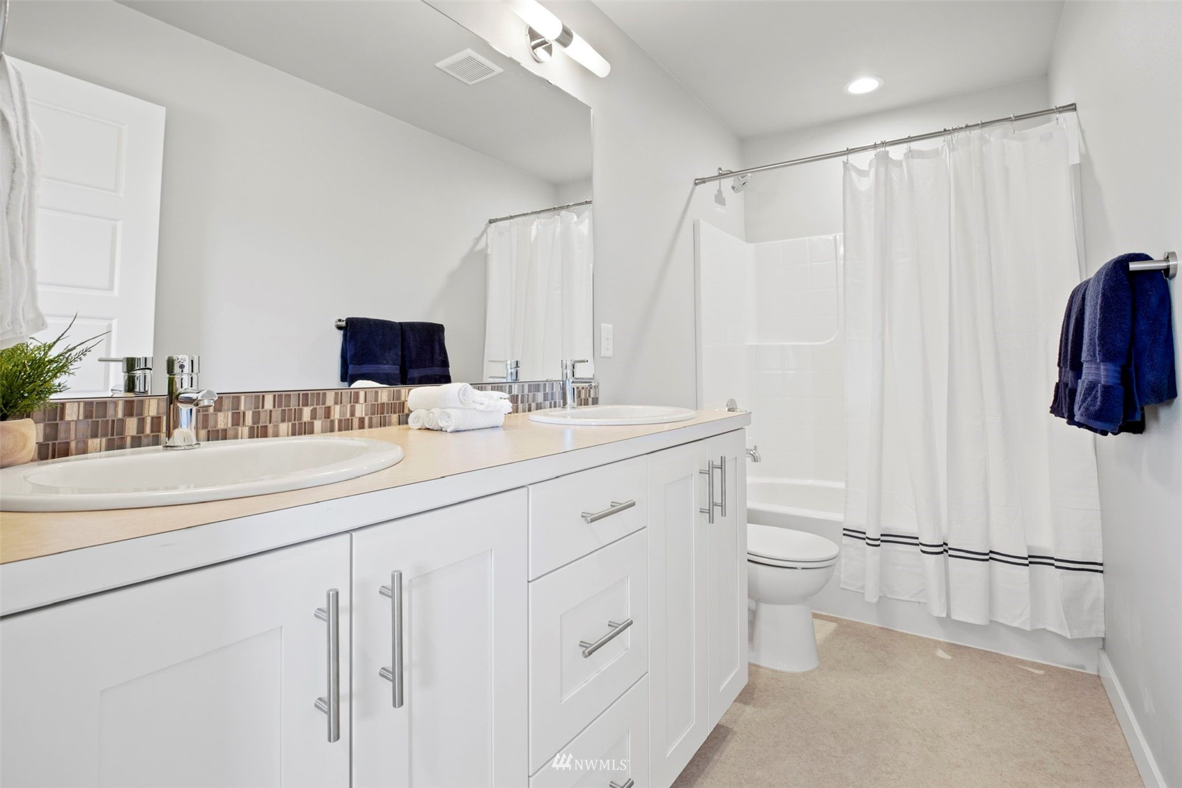 1325 Seattle Hill Road, Unit F1 Bothell, WA 98012 - Photo 26 of 34 a bathroom with a double vanity sink toilet and a mirror