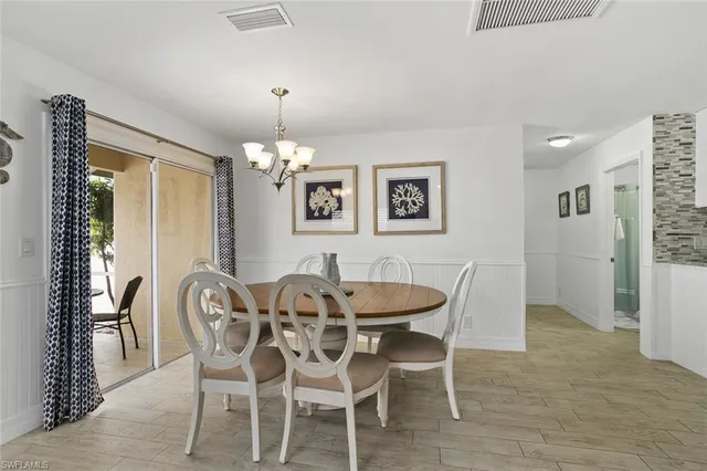 a dining room with furniture a chandelier and wooden floor