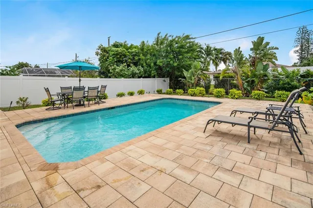 a view of a swimming pool with a yard and sitting area