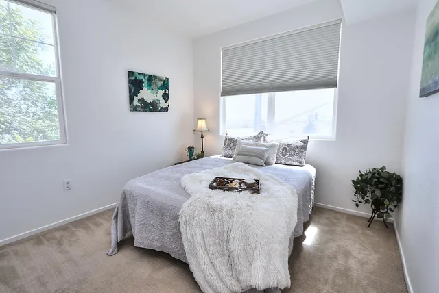 a bedroom with a bed and a painting on the wall