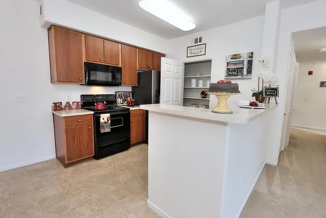 a kitchen with stainless steel appliances granite countertop a refrigerator and a stove top oven