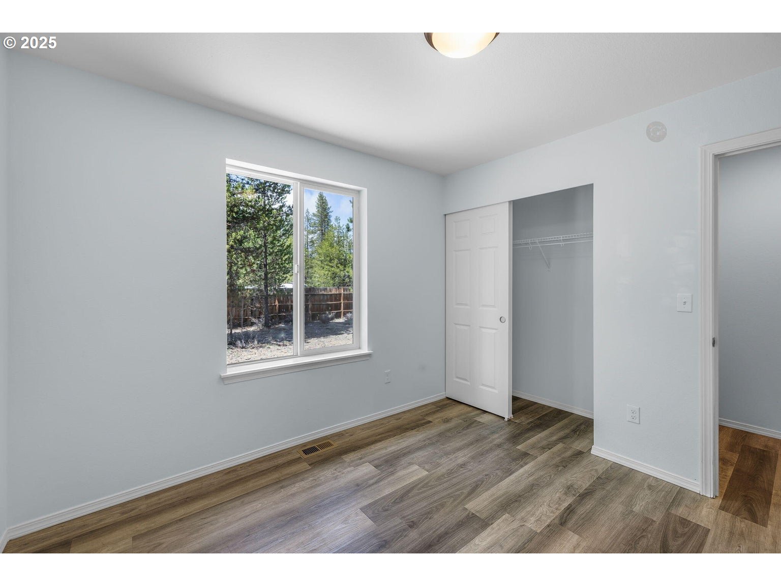 11421 Burlwood Road La Pine, OR 97739 - Photo 15 of 31 a view of an empty room with wooden floor and a window