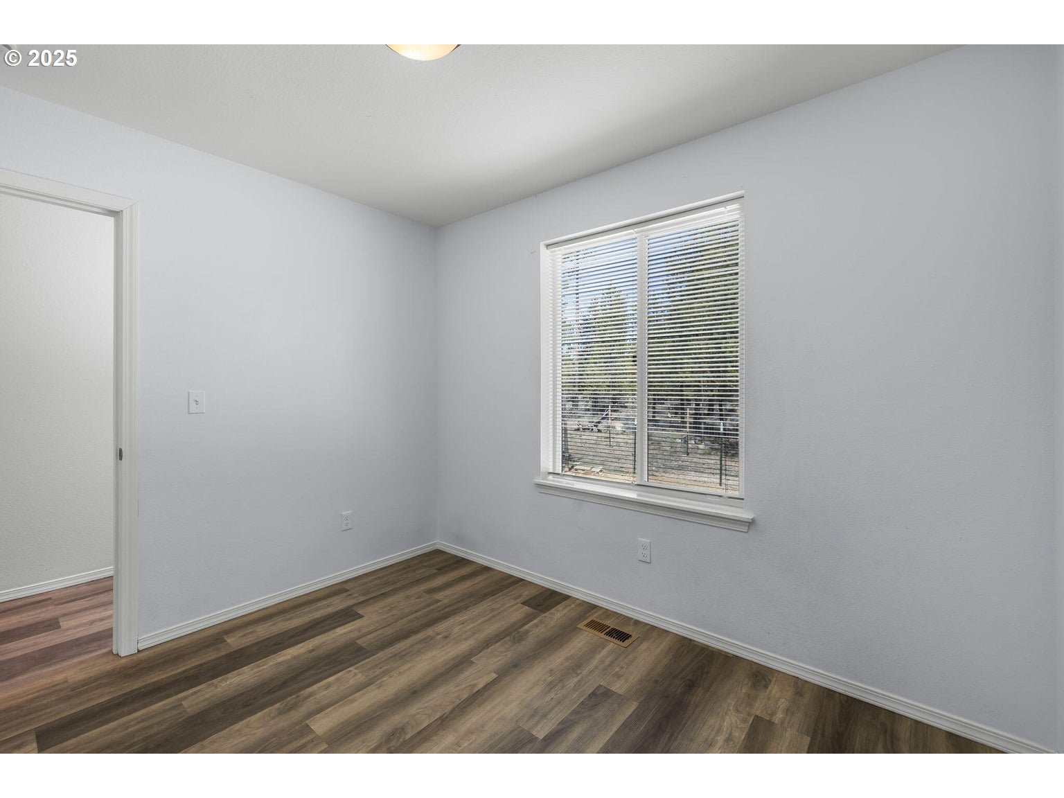 11421 Burlwood Road La Pine, OR 97739 - Photo 19 of 31 a view of an empty room with wooden floor and a window