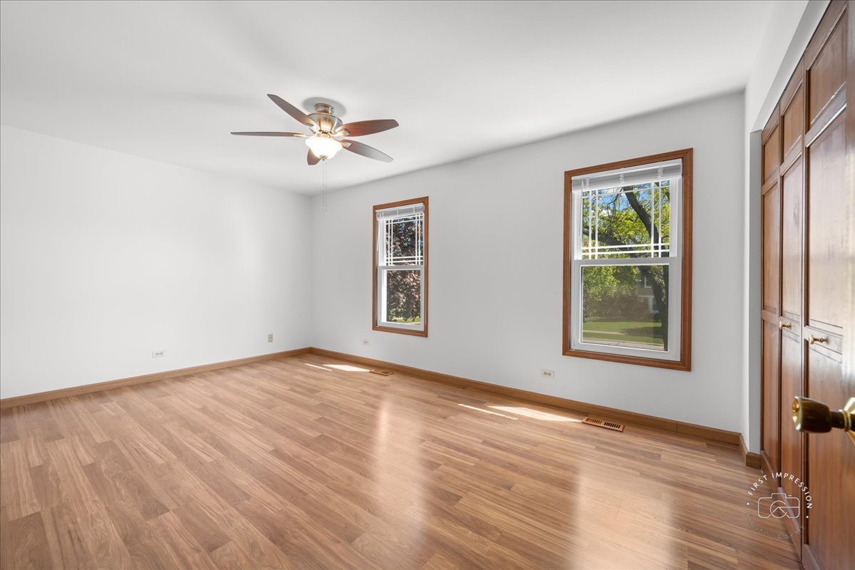 375 Hunter Drive Carol Stream, IL 60188 - Photo 17 of 20 a view of an empty room with a window and wooden floor