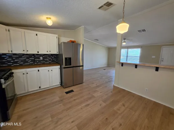 a view of room with hardwood floor and a ceiling fan
