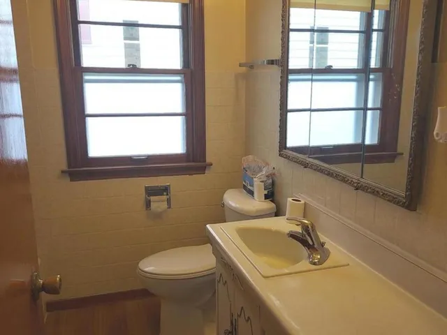 a bathroom with a sink toilet and window