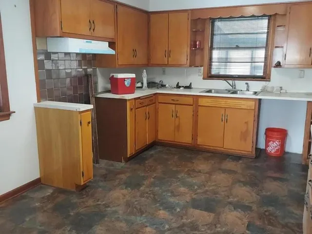 a kitchen with stainless steel appliances granite countertop a sink a stove and a refrigerator