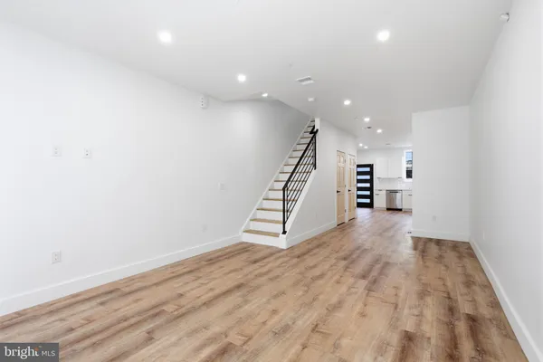 an empty room with wooden floor and stairs