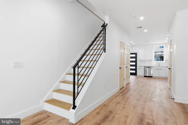 a view of a hallway with wooden floor and staircase